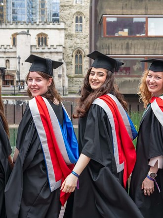 Four females at graduation at the water front at the Barbican Centre