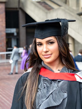 Female in gown outside at graduation at the Barbican Centre