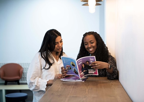 Two females looking at University of Law prospectus