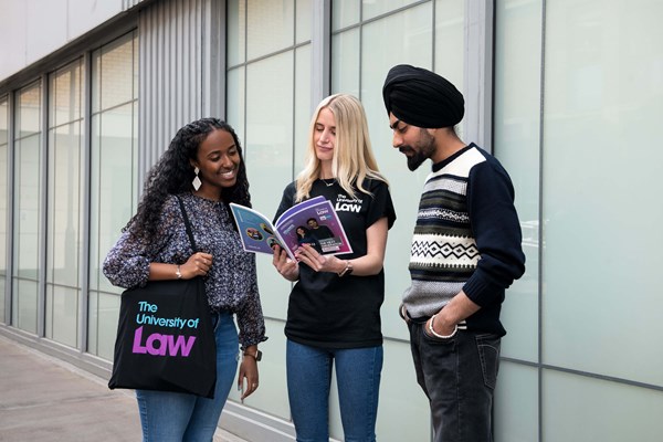 Event attendees looking at University of Law prospectus